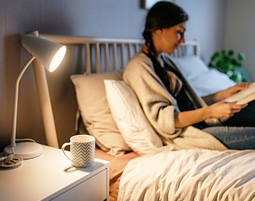 une femme au lit prenant le thé
