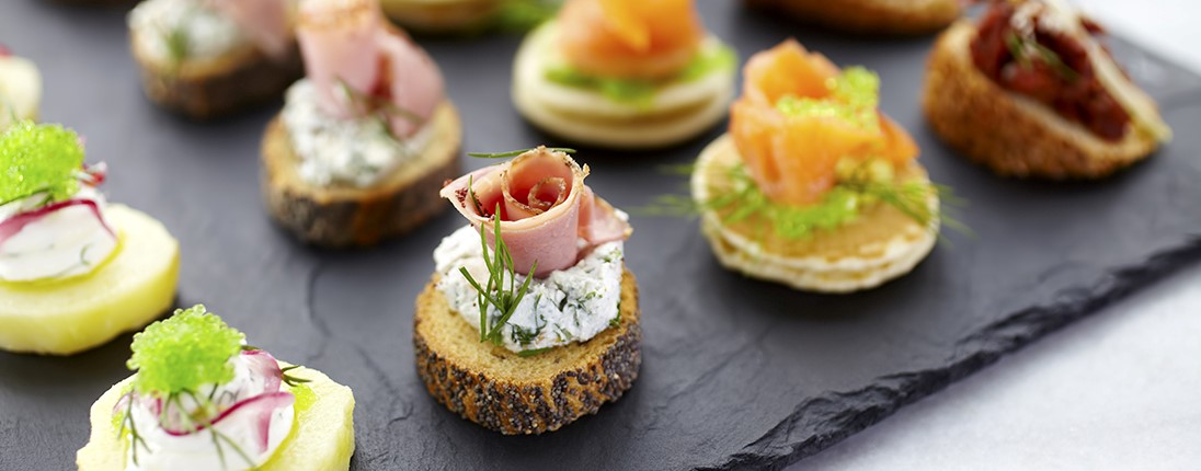 Des canapés pour l’apéro disposés sur une ardoise