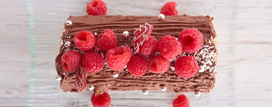 Une bûche de noël à la framboise disposée sur une table