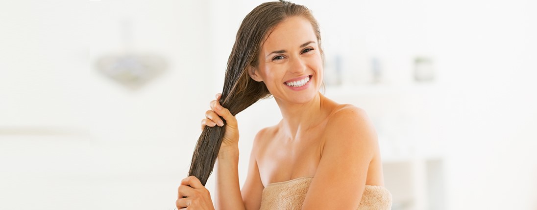 Une femme applique un soin sur ses cheveux