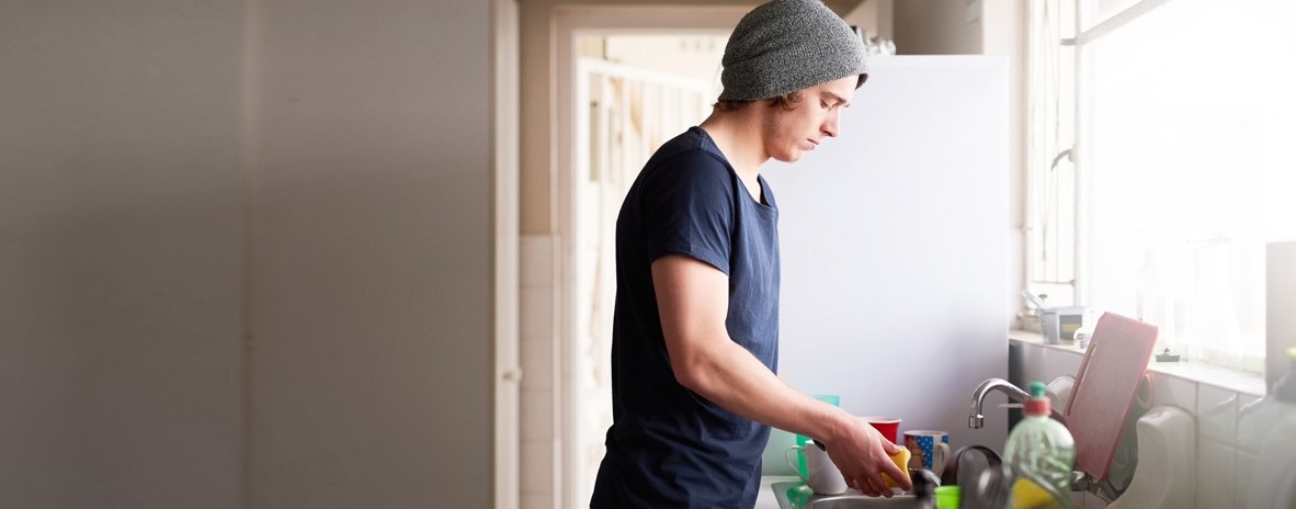 Un jeune homme fait la vaisselle
