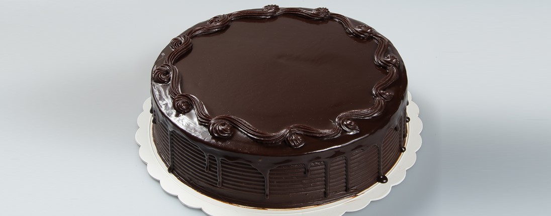 Un gâteau avec un glaçage au chocolat disposé sur une assiette