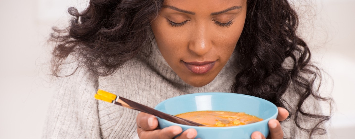 Une femme s’apprête à déguster un bol de soupe