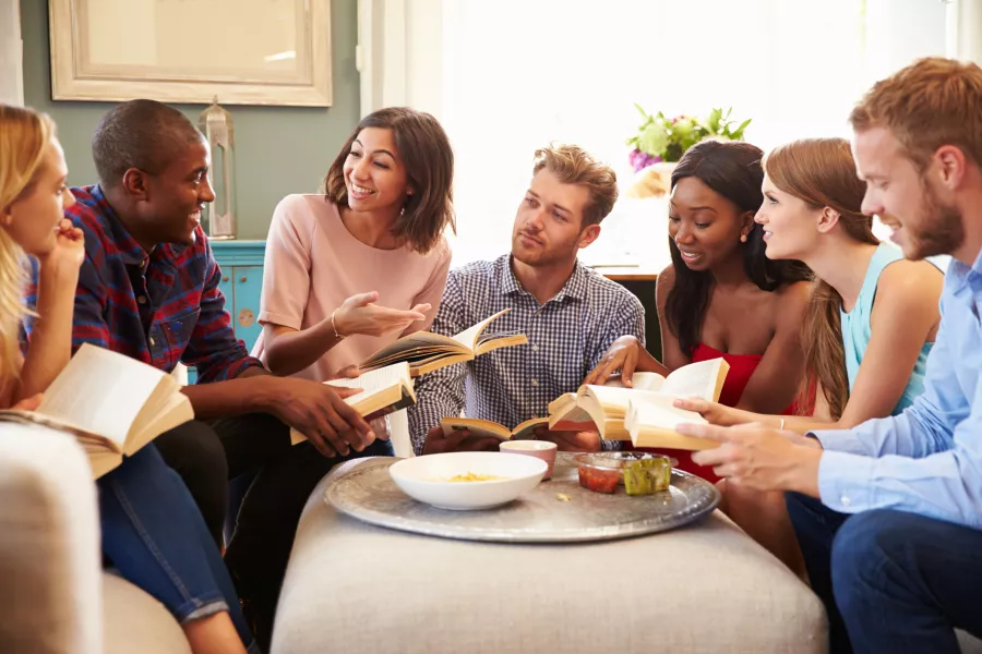 Des amis discutent de livres à l’apéritif.