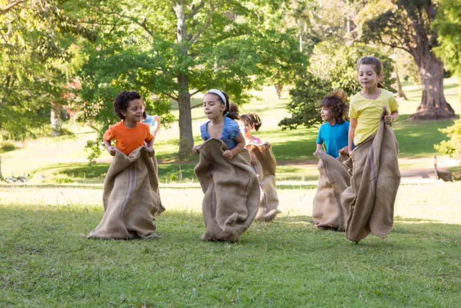 Des enfants font une course en sacs