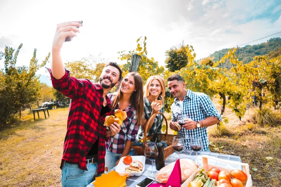 Un groupe d’amis fait un selfie lors d’un pique-nique dans les vignes