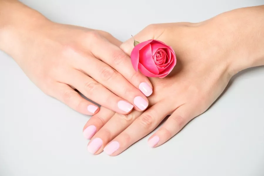 Des pieds de femme aux ongles vernis rose poudré