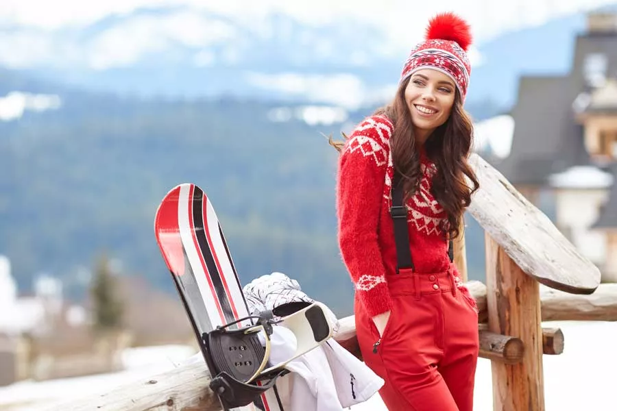 Une femme fait une pause dans sa journée au ski. 