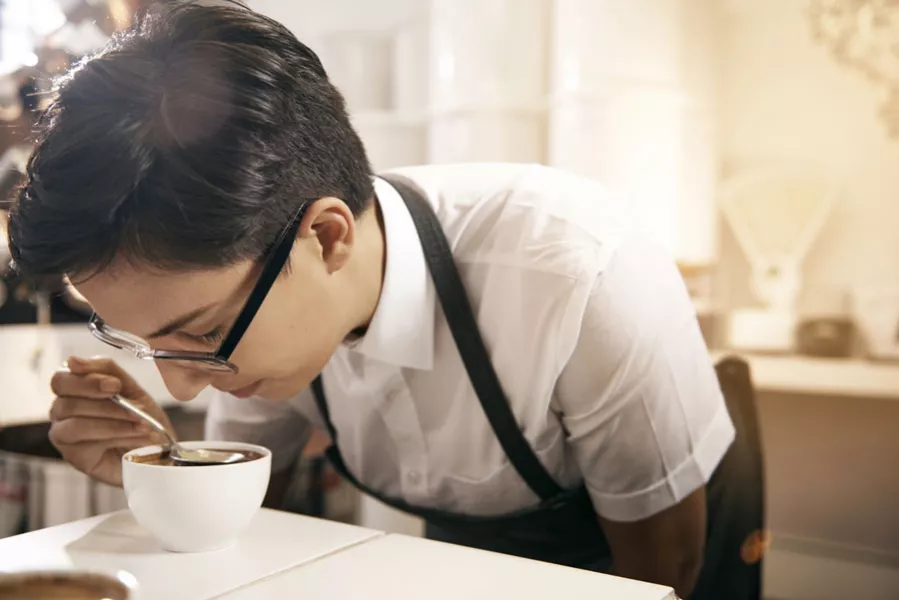 Un homme déguste un café dans la tradition du cupping