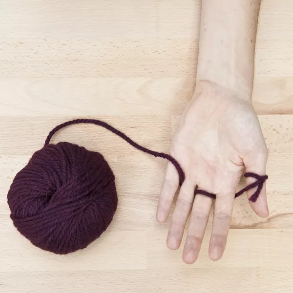 Etape 2 : passer la laine entre les doigts de gauche à droite…