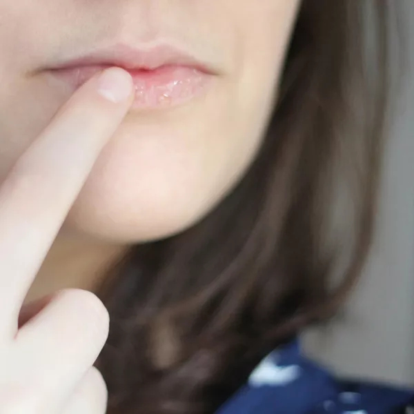 une femme se met du baume à lèvre