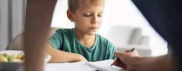 Un petit garçon fait ses devoirs avec sa maman