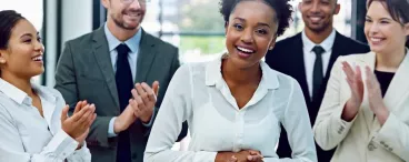 Une jeune femme complimentée par ses collègues