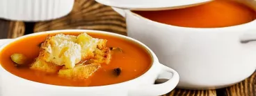 Un bar à croûtons sur une planche, avec Pelletier De la soupe accompagnée de croûtons