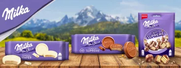 Les packs Milka Supreme chocolat, blanc et mini sur une table devant la montagne Milka