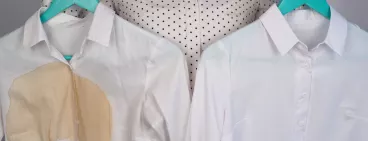 Une chemise avec une tâche et une chemise propre blanche