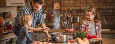Un père cuisine un plat 