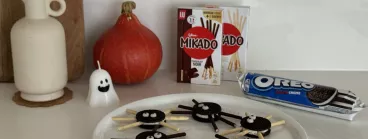Les araignées en Oreo et Mikado dans une assiette avec des packs d'Oreo et de Mikado en fond