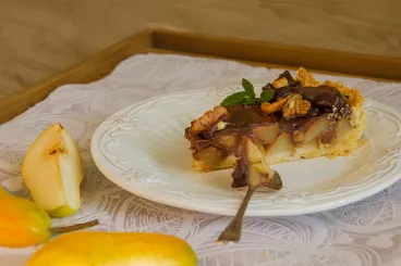 Une part de tarte poire chocolat dans une assiette. 