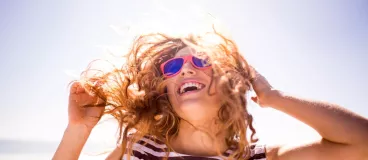 Je prépare mes cheveux pour l'été Une femme profite du soleil sur une plage