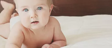 Un bébé à plat ventre sur un lit