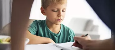 Un petit garçon fait ses devoirs avec sa maman