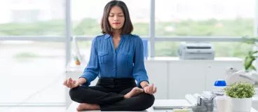 10 astuces pour être zen au bureau Une femme fait du yoga