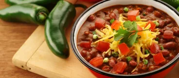 Un plat de chili con carné entouré de légumes