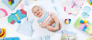 Un bébé entouré de sa garde robe