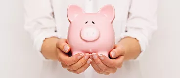 Petit guide pour limiter sa consommation et faire des économies Une tirelire dans les mains d’une femme