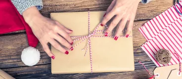 Une femme emballe un livre de cuisine pour l’offrir à Noël