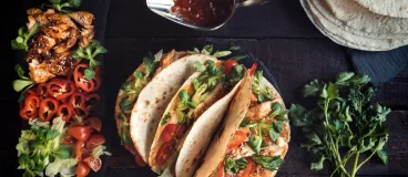 Des tacos au poulet, des poivrons, des tomates, du basilic, et de la sauce Barbecue Amora.