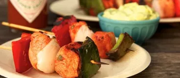 Des petites brochettes apéritives de poulet marinées au TABASCO® Rouge avec une sauce avocat 