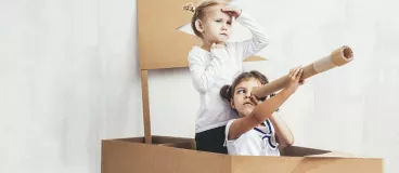 enfants jouant dans un bâteau en carton