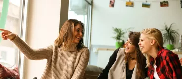 Un groupe de femmes partage un moment entre amis autour d’un café.