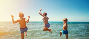 Une famille court sur une plage pour se baigner