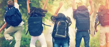 Un groupe d’écoliers exécutent ensemble un saut sur le chemin de l’école