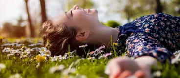 Une femme est allongée dans l’herbe dans un parc.
