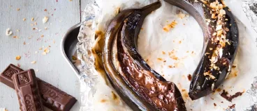 Des bananes en papillotes disposées sur une table