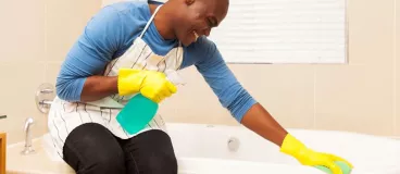 Un homme nettoie la salle de bain