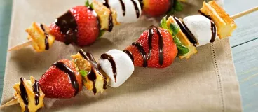 Des brochettes de churros, fraises et chocolat