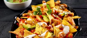 Bouchées de dinde tex-mex au barbecue et nachos au cheddar fondu Un plat de nachos