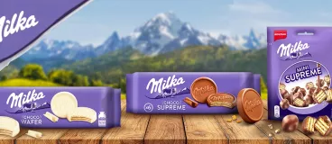 Les packs Milka Supreme chocolat, blanc et mini sur une table devant la montagne Milka