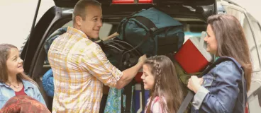 Le toit d’une voiture jaune chargé de vélos et bagages pour les vacances