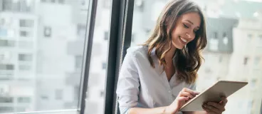 Couple souriant sur un canapé regardant leur écran d’ordinateur