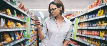 Une femme regardant son smartphone faisant les courses