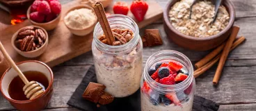 Deux pots d’overnight oats aux fruits rouges et au chocolat Côte d’Or posés sur une table