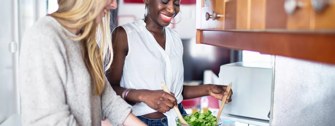 Deux femmes cuisinent des légumes. 