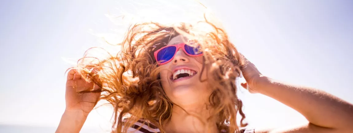 Je prépare mes cheveux pour l'été Une femme profite du soleil sur une plage