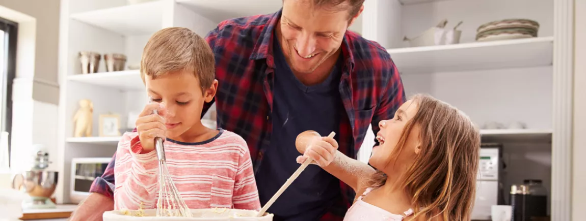 Un père et ses enfants font la cuisine